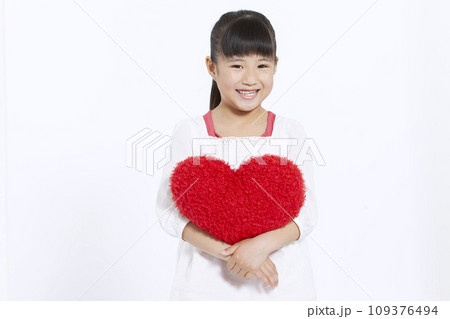 ハートのクッションを持つ女の子 109376494