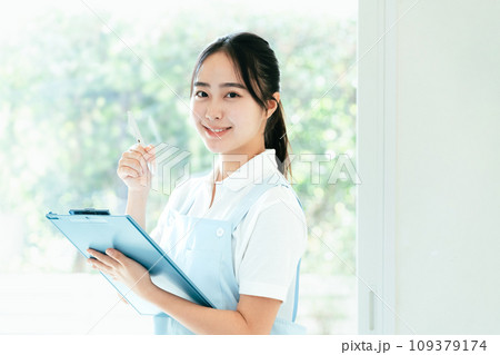 窓際に立つ介護士の若い女性 109379174