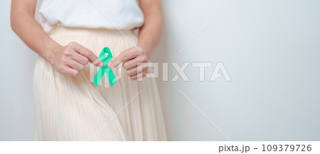 Woman holding Teal Ribbon on abdomen for January Cervical Cancer Awareness month. Uterus and Ovaries, Cervix, Endometriosis, Hysterectomy, Uterine fibroids, Reproductive and World cancer day concept Woman holding Teal Ribbon on abdomen for January Cervical Cancer Awareness month. Uterus and Ovaries, Cervix, Endometriosis, Hysterectomy, Uterine fibroids, Reproductive and World cancer day concept 109379726