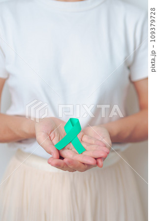 woman holding Teal Ribbon for January Cervical Cancer Awareness month. Uterus and Ovaries, Cervix, Endometriosis, Hysterectomy, Uterine fibroids, Reproductive, Healthcare and World cancer day 109379728