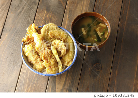 海老、ちくわ、インゲン、カボチャ、さつま芋、蓮根が乗っている具だくさんの天丼とお味噌汁 109381248