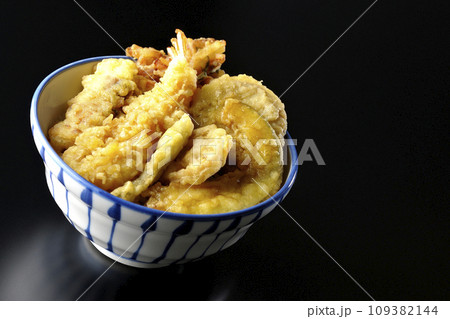 海老、ちくわ、インゲン、カボチャ、さつま芋、蓮根が乗っている具だくさんの天丼を黒背景で撮影 海老、ちくわ、インゲン、カボチャ、さつま芋、蓮根が乗っている具だくさんの天丼を黒背景で撮影 109382144