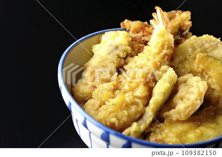 海老、ちくわ、インゲン、カボチャ、さつま芋、蓮根が乗っている具だくさんの天丼を黒背景で撮影 海老、ちくわ、インゲン、カボチャ、さつま芋、蓮根が乗っている具だくさんの天丼を黒背景で撮影 109382150