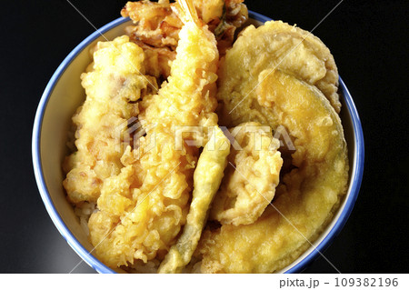 海老、ちくわ、インゲン、カボチャ、さつま芋、蓮根が乗っている具だくさんの天丼を黒背景で俯瞰撮影 109382196