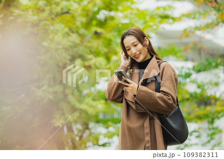 屋外を歩くコートの女性 屋外を歩くコートの女性 109382311