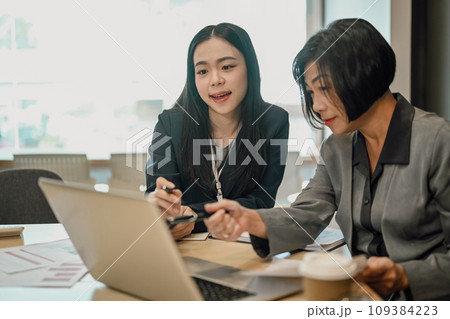 Senior female ceo and young female worker discussing company presentation at meeting table Senior female ceo and young female worker discussing company presentation at meeting table 109384223