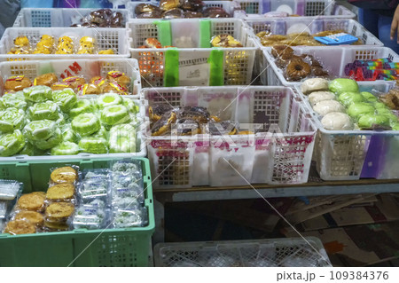 Many varieties of traditional snacks sold in the Marketplace in dawn time in Surabaya, East Java, Indonesia. Many varieties of traditional snacks sold in the Marketplace in dawn time in Surabaya, East Java, Indonesia. 109384376