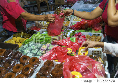 Many varieties of traditional snacks sold in the Marketplace in dawn time in Surabaya, East Java, Indonesia. Many varieties of traditional snacks sold in the Marketplace in dawn time in Surabaya, East Java, Indonesia. 109384378