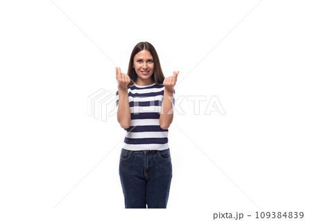 attractive young caucasian brunette woman in a striped t-shirt points with her hands to the 109384839