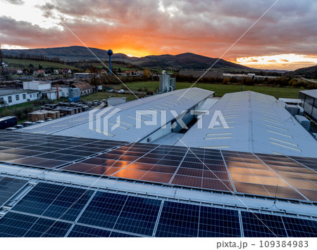 Aerial view of solar panels on a rooftop of factory. Solar energy as renewable energy source in business. 109384983
