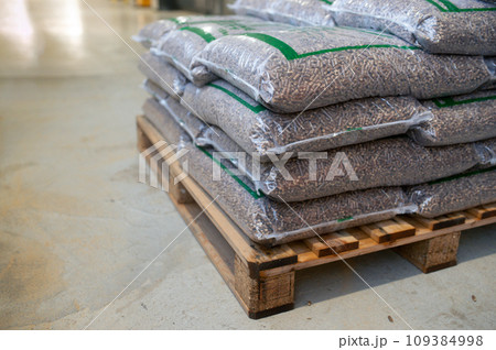 Bags with wood pellets, pellet fuels manufactured in wood pellet line. Reusing wooden industrial waste. Bags with wood pellets, pellet fuels manufactured in wood pellet line. Reusing wooden industrial waste. 109384998