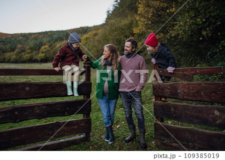 Portrait of family outdoors going on walk in nature. Mother, father and kids spending time outdoors during cold autumn day. 109385019