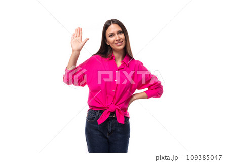 young slender brunette leader woman in a bright pink shirt shows a gesture of welcome 109385047