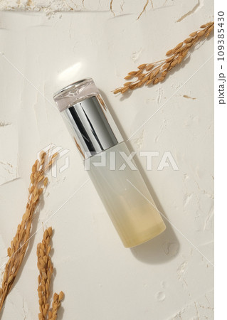 View from above of a beauty bottle placed on rice bran powder, decorated with wheat ears. Branding mockup. Rice water will help restore hair damage View from above of a beauty bottle placed on rice bran powder, decorated with wheat ears. Branding mockup. Rice water will help restore hair damage 109385430