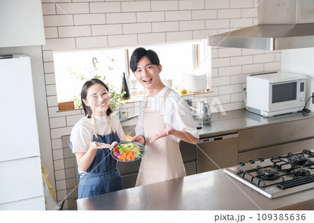 キッチンで笑顔の夫婦（料理・家事） 109385636