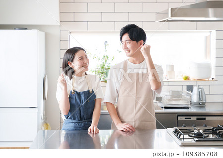 キッチンでガッツポーズする夫婦（料理・家事） 109385708