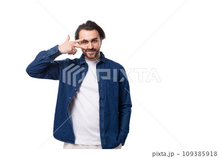 young well-groomed brunette guy in a casual blue shirt on a white coin with copy space young well-groomed brunette guy in a casual blue shirt on a white coin with copy space 109385918