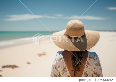 Woman in summer vacation wearing straw hat enjoying the view at the ocean. Back view. Generative Ai Woman in summer vacation wearing straw hat enjoying the view at the ocean. Back view. Generative Ai 109386642