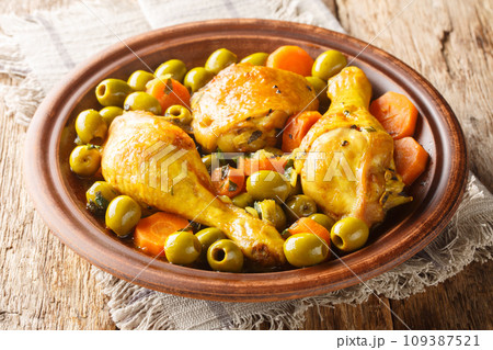 Tajine zitoune is a chicken mix vegetables ad spices cuisine close-up on wooden table. Horizontal 109387521