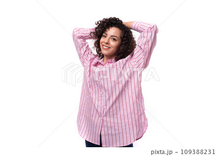 young successful curly caucasian woman dressed in a striped pink blouse 109388231