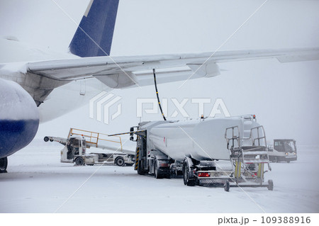 Refueling of airplane at airport during snowfall. Refueling of airplane at airport during snowfall. 109388916
