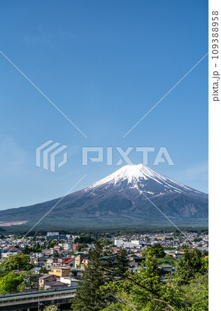 【山梨県】春の快晴の空と雪の積もる富士山と麓の街並み（4月） 109388958