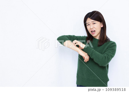乾燥で肌を搔きむしる40代の女性 109389518