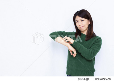 乾燥で肌を搔きむしる40代の女性 109389520