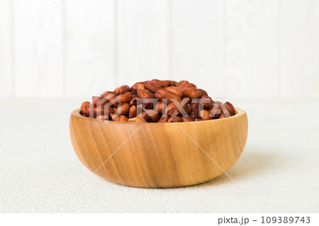 Fresh healthy peanuts in bowl on colored table background. Top view Healthy eating bertholletia concept. Super foods Fresh healthy peanuts in bowl on colored table background. Top view Healthy eating bertholletia concept. Super foods 109389743