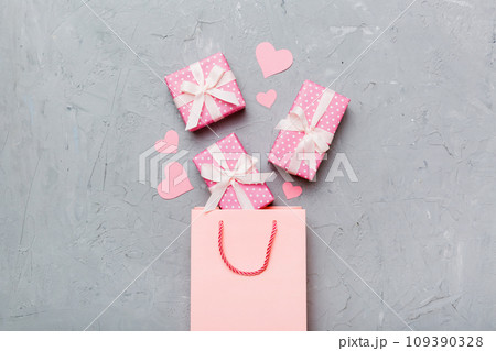 Gift boxes pop out from paper bag top view on colored background. bag packing handmade boxes fall out Concept of holidays, shopping, sale, discounts. Top view, flat lay 109390328