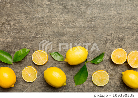 Many fresh ripe lemons with green leaves on colored background, top view, space for text Many fresh ripe lemons with green leaves on colored background, top view, space for text 109390338