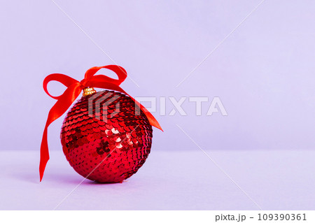 Christmas ball on colored background. decoration bauble with ribbon bow with copy space Christmas ball on colored background. decoration bauble with ribbon bow with copy space 109390361
