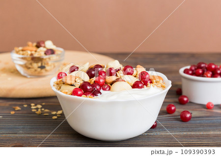 Healthy breakfast food with granola, yogurt, fruits and nuts. Dessert parfait with dried fruits for breakfast 109390393
