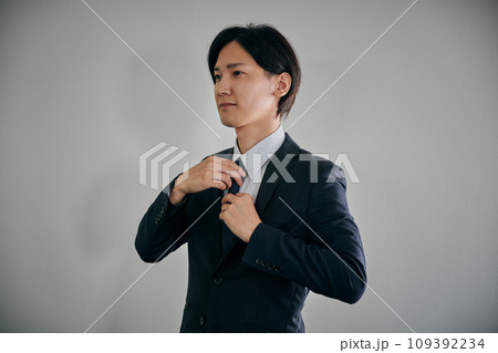 スーツを着て身支度をする若い男性 スーツを着て身支度をする若い男性 109392234