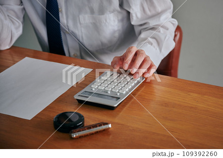 電卓で計算をする若い男性の手 109392260