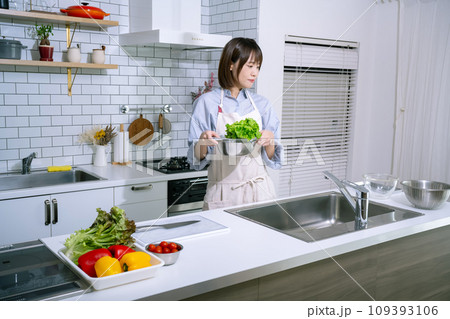 キッチンでサラダを作る女性 キッチンでサラダを作る女性 109393106