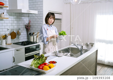 キッチンでサラダを作る女性 キッチンでサラダを作る女性 109393108