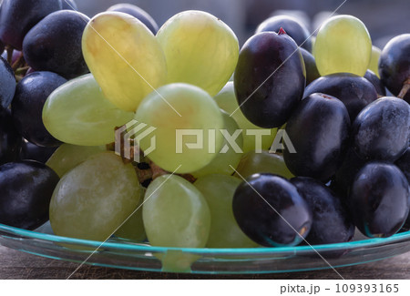 Close-up of Fresh Green seedless and Black seedless Grapes. 109393165
