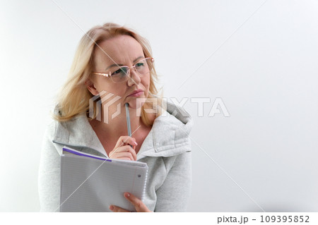 a journalist describes the situation wearing glasses, a middle-aged woman with a notepad listens attentively looks into the frame blond hair raises her finger up a journalist describes the situation wearing glasses, a middle-aged woman with a notepad listens attentively looks into the frame blond hair raises her finger up 109395852