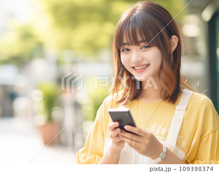 スマホを操作する笑顔の女性 109398374