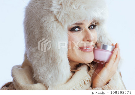 happy stylish woman in winter coat and fur hat on white 109398375