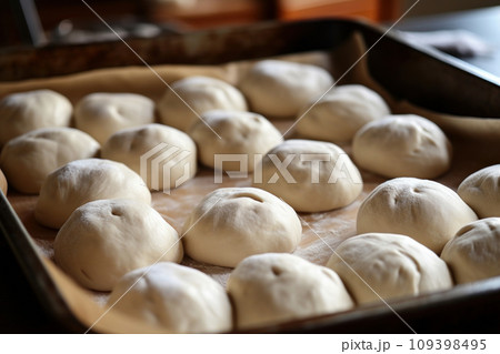 Balls of raw dough in a baking tray 109398495