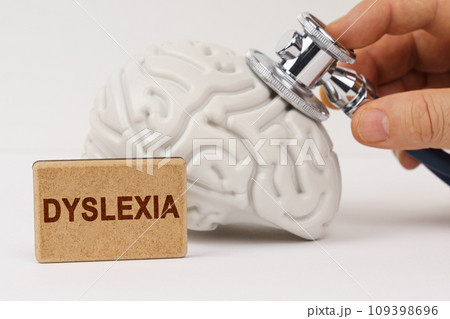 Using a stethoscope, the brain is diagnosed, next to it is a sign with the inscription - Dyslexia 109398696