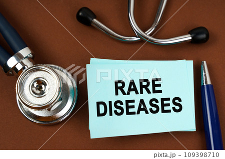 On a brown surface there is a stethoscope, a pen and blue stickers with the inscription - RARE DISEASES On a brown surface there is a stethoscope, a pen and blue stickers with the inscription - RARE DISEASES 109398710