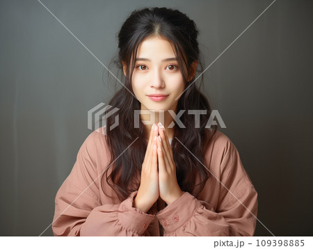 両手を合わせる女性 109398885