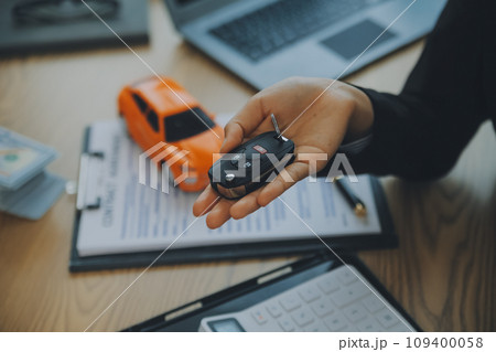 Salesman send key to customer after good deal agreement, successful car loan contract buying or selling new vehicle. Salesman send key to customer after good deal agreement, successful car loan contract buying or selling new vehicle. 109400058