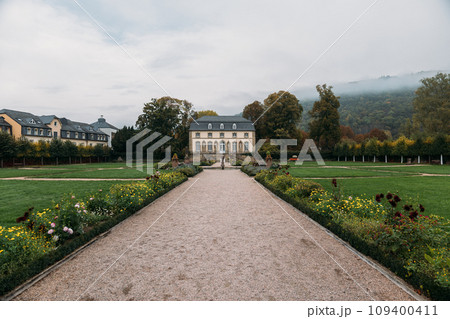 Orangery in middle of lawn with planted flowers among nature Orangery in middle of lawn with planted flowers among nature 109400411