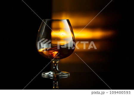 Snifter of brandy on a black background. 109400593