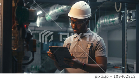 African American inspector checks pipeline system on factory 109402815