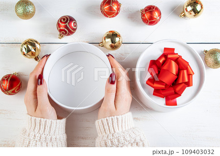Woman holds in her hands beautiful gift box with red bow on white background. Woman holds in her hands beautiful gift box with red bow on white background. 109403032